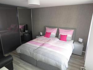 een slaapkamer met een groot bed met roze kussens bij Ferienwohnung Frühlings in Medebach