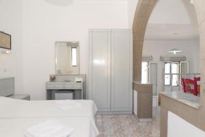 a white bathroom with a sink and a table at Captain Manos Studio Apartments in Grikos