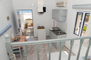 a small kitchen with a sink and a table at Captain Manos Studio Apartments in Grikos