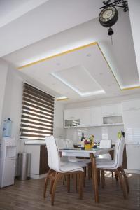 a kitchen with a table and chairs and a clock on the ceiling at Apartments Sunny Hill in Tivat
