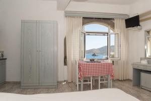 a kitchen with a table and a window at Captain Manos Studio Apartments in Grikos