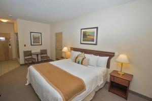 A bed or beds in a room at Lakeview Inns & Suites - Chetwynd