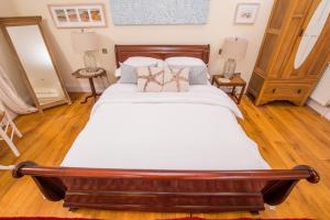 a bedroom with a large bed with white sheets and pillows at The Garden Studio in Budleigh Salterton