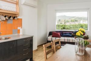 a kitchen with a table and a living room with a couch at Casa Azul da Beija in Furnas