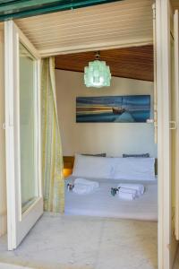 a bedroom with a bed with white sheets and towels at Casa Piano di Gallo in Mondello