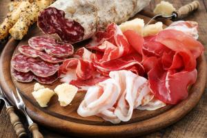 a plate of food with meats and cheese on a table at Agriturismo Al Palaz in Prata Camportaccio +59 photos