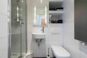ein Bad mit einem WC, einem Waschbecken und einer Dusche in der Unterkunft Gepflegte und moderne Ferienwohnung in der Neuseenlandschaft in Neukieritzsch