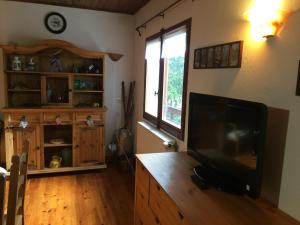 a living room with a flat screen tv on a wooden cabinet at Chalet de l'Esquirol in Bolquere Pyrenees 2000
