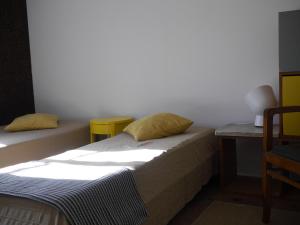 a small bedroom with a bed and a table at ribeira dos marinheiros amarelo in Sintra