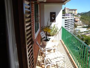 a balcony with two chairs and a view of a city at FLATs CAVALINHO BRANCO in Águas de Lindoia