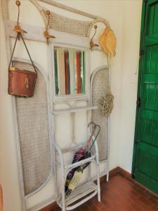 a room with a chair and a shelf with books at Case Davanti al Mare con Ampio Giardino e Parcheggio Gratuito in Santa Caterina