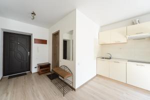 キーウにあるComfortable apartment near airport Zhulynyの白いキャビネットと黒いドア付きのキッチン