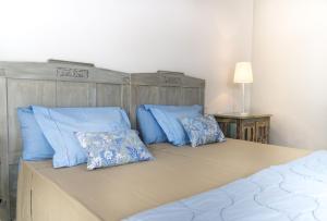 ein Schlafzimmer mit einem Bett mit blauen Kissen darauf in der Unterkunft Marietaland in Campos