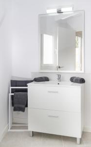 ein weißes Badezimmer mit einem Waschbecken und einem Spiegel in der Unterkunft Marietaland in Campos