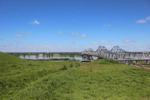 ナチェズにあるThe Bridges Hotelの緑の野原の隣の川にかかる橋