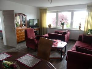 ein Wohnzimmer mit roten Stühlen und einem Tisch in der Unterkunft Ferienwohnung Anke - Appartement 5b in Heinsberg