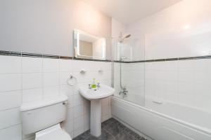 une salle de bain blanche avec toilettes et lavabo dans l'établissement Ultra Urban Belfast Apartments, à Belfast 231 autres photos