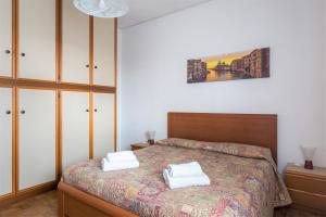 ein Schlafzimmer mit einem Bett mit zwei weißen Handtüchern darauf in der Unterkunft Home Near Venice in Favaro Veneto