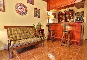 una habitación con un banco y un bar con reloj en Hosteria Lucky Home en Mar del Plata