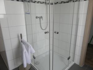 a bathroom with a shower with white towels at Ferienwohnung Anke - Apartment 5d in Heinsberg