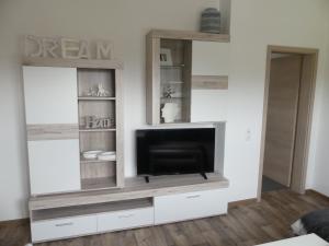 una sala de estar con un centro de entretenimiento con TV de pantalla plana en Ferienwohnung Anke - Apartment 5d en Heinsberg