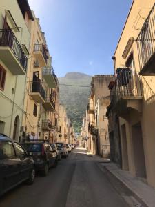 an empty street with cars parked on the sides of buildings at Alice's Apartment in Castellammare del Golfo