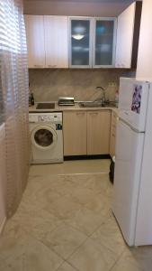 a kitchen with a white refrigerator and a washing machine at Club Priz in Primorsko