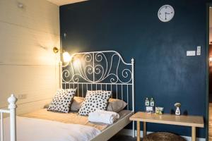 een slaapkamer met een bed en een blauwe muur bij Yoo Yen Pen Sook in Bangkok