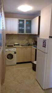 a kitchen with a white refrigerator and a dishwasher at Club Priz in Primorsko