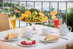 a table with a plate of food and a bowl of fruit at Hotel Capizzo in Ischia
