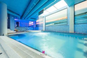 格羅韋的住宿－羅拉特碼頭&Spa四星高級酒店，大楼内的一个蓝色海水游泳池