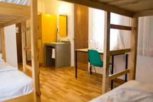 a dorm room with a desk and a bunk bed at Hostal Tres Central in Tuxtla Gutiérrez