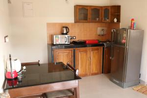 uma cozinha com um frigorífico de aço inoxidável e armários de madeira em Asian Golden Sands - S7 & S8 em Benaulim