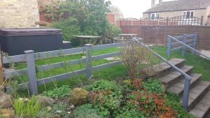 a garden with a blue fence and some flowers at Sands Farm Cottages in Thornton Dale