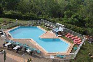 an overhead view of a large swimming pool with lounge chairs and sidx sidx at Le Neoulous in Le Boulou