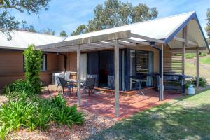 a pavilion with a table and chairs on a patio at Condo 105 @ Horizons Golf Resort - Salamander Bay NSW in Salamander Bay