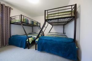 two bunk beds in a room with blue sheets at Condo 105 @ Horizons Golf Resort - Salamander Bay NSW in Salamander Bay