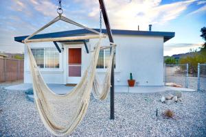 a hammock in front of a house at M&L Desert Cottage - 6 min To North Entry Of JTNP! in Twentynine Palms