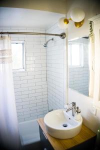 a white bathroom with a sink and a shower at M&L Desert Cottage - 6 min To North Entry Of JTNP! in Twentynine Palms