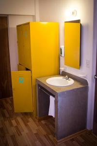 ein Badezimmer mit einem Waschbecken und einer gelben Wand in der Unterkunft Hostal Tres Central in Tuxtla Gutiérrez