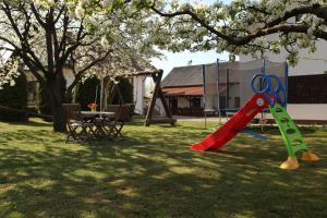 a playground with a slide and a table in a yard at Guest House Gacka Rogić in Otočac