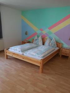 a bedroom with a bed with a colorful wall at Landgasthof Astner in Münster