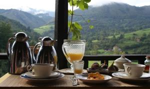 a table with a glass of orange juice and a drink at La Casona de Con in Mestas de Con