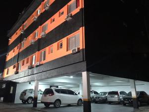 un estacionamiento con autos estacionados frente a un edificio en Hotel Romance (Adults Only) en São Paulo