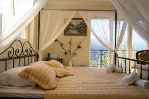 een slaapkamer met een bed met kussens en een raam bij Apartments Golden View in Kotor