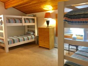 ein Schlafzimmer mit zwei Etagenbetten und einem Schreibtisch in der Unterkunft Cedarwalk in Killington