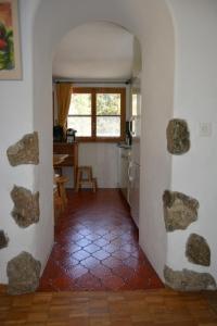 un pasillo que conduce a una cocina con rocas en la pared en Apartment Bos-cha, en La Punt-Chamues-ch