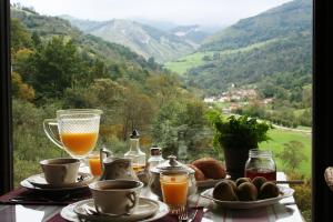 - une table avec un petit-déjeuner composé de jus d'orange et de pain dans l'établissement La Casona de Con, à Mestas de Con