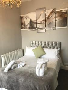 een slaapkamer met een bed met witte handdoeken bij 7 Llewelyn Avenue in Llandudno