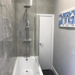 een badkamer met douche en ligbad bij 7 Llewelyn Avenue in Llandudno